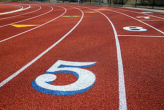 St. John's - Lane Marking on REGUPOL champion AG Track The number "5" is painted in white on St. John's REGUPOL champion AG running track, marking a specific lane.