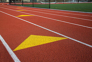 St. John's Finish Line Indicator on REGUPOL champion AG Track A yellow arrow is painted on St. John's running track, directing runners towards the finish line.