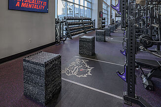 In-depth view of REGUPOL crash platforms in the TCU football performance center with a view of the TCU football stadium in the background.