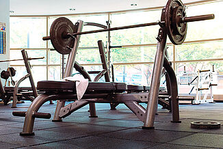 Temple University Fitness - Weight Bench with Weights A weight bench with weights on it in Temple University's fitness center, positioned on REGUPOL aktipro rubber flooring.