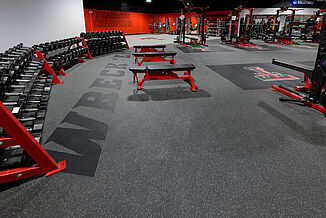 Inlaid messaging in the free weight area of the Texas Tech Volleyball weight room.