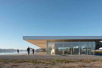 Neil Campbell Rowing Centre - Rowers Entering the Facility Daytime view of the Neil Campbell Rowing Centre facility, with rowers utilizing the convenience of proximity to the water.