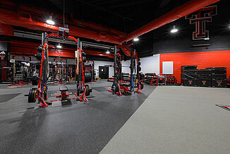 View of the transition between REGUPOL aktivpro roll flooring and the turf area in the Texas Tech Volleyball weight room. The combination of flooring allows for increased training capabilities.