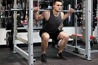 UFC Gym - Squatting on REGUPOL aktiv Flooring Athlete performs a weighted squat on REGUPOL aktiv rolled rubber flooring in the UFC Gym. The floor provides a stable and comfortable environment for heavy weight training to take place.