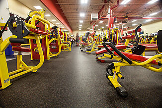 Retro Fitness Stroudsburg members working out on custom REGUPOL floors that match the vibrancy of fitness equipment.