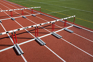 St. John's REGUPOL champion AG Track Ready for Competition White hurdles are neatly arranged on St. John's REGUPOL champion AG running track.
