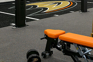 Anaheim Ducks Training Facility - REGUPOL aktivpro roll and Turf The Anaheim Duck's training facility features REGUPOL aktivpro roll flooring that seamlessly transitions into a turf area. The facility allows athletes to perform a variety of exercises, from weight training to cardio.